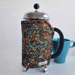 Kaffevarmer med kaffeb�nner p� turkis bund