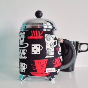 Kaffevarmer i sort med hvide og rde kopper 